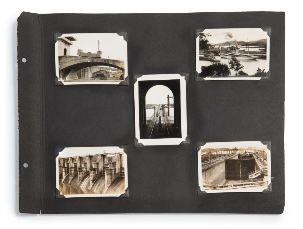 A single black photo album page, showing five black and white small photographs.