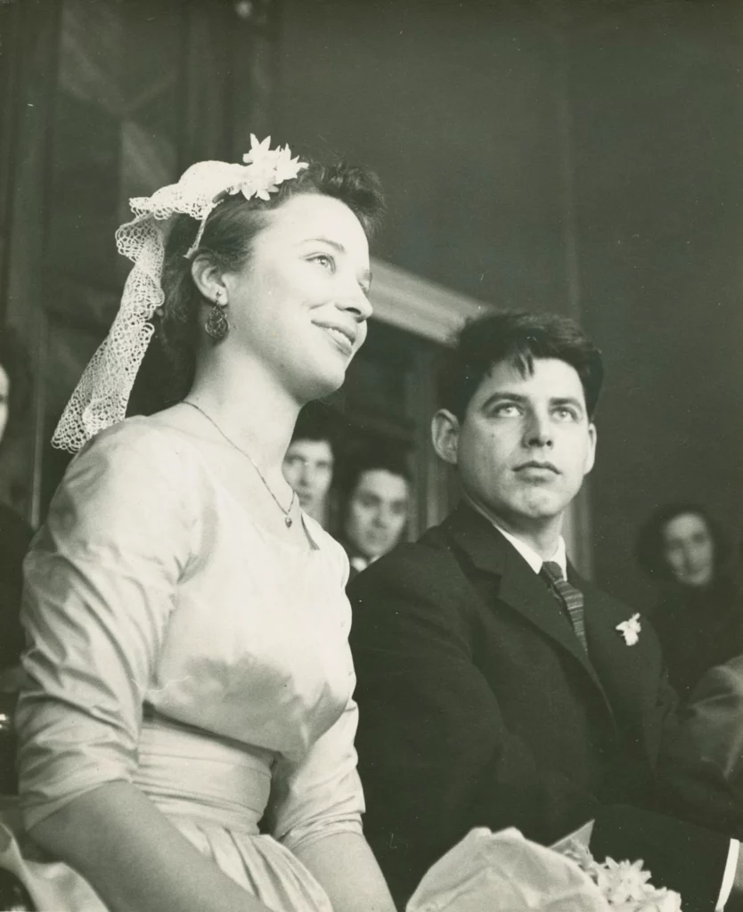 A black and white photograph from 1957 of a bride and groom, both with light skin tones, seated at a marriage ceremony.