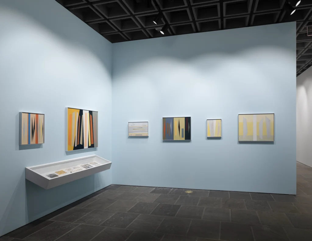 An installation photograph of abstract artwork on light blue walls.